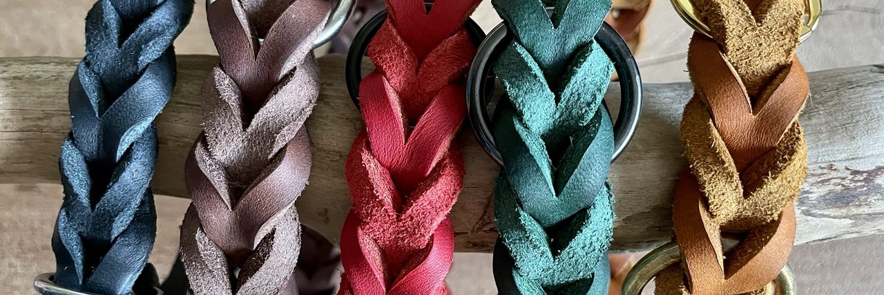 Fünf handgeflochtene Fettleder-Halsbänder in Blau, Altrosa, Rot, Petrol und Cognac